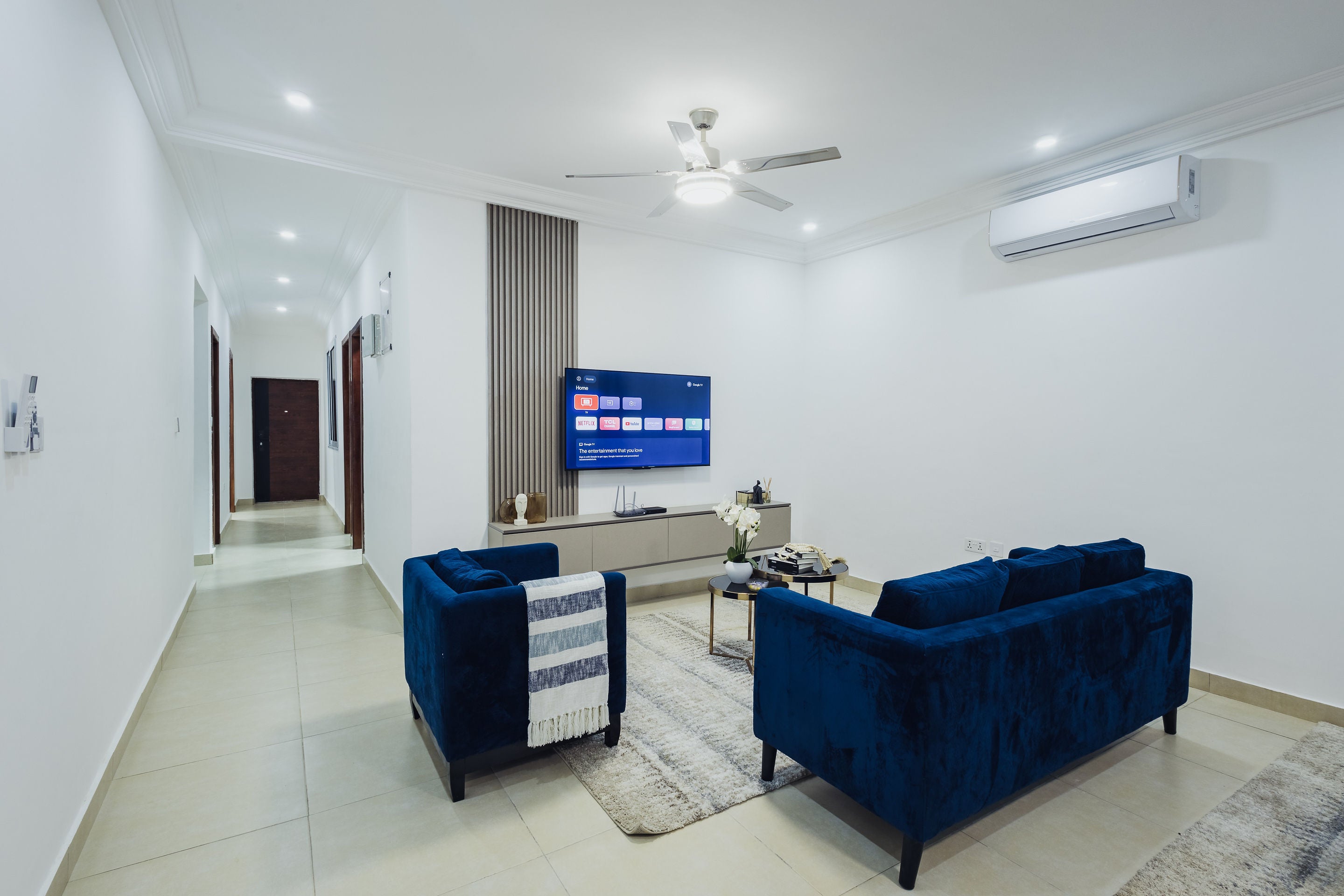 Lounge with twin navy sofas and smart TV