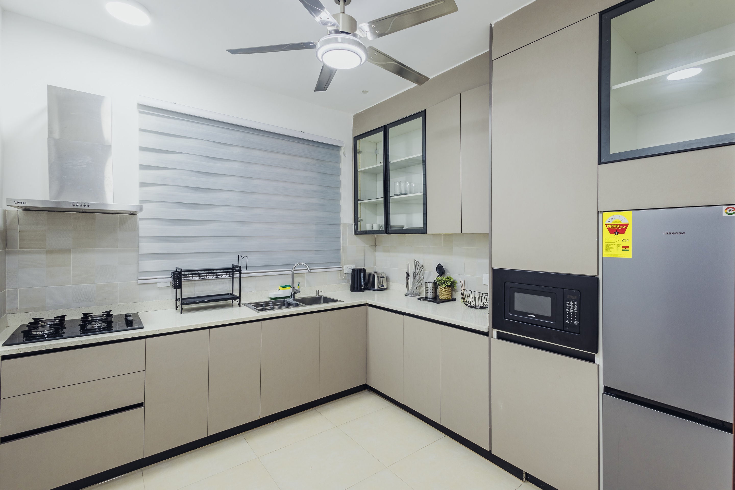 Kitchen with gas hob, microwave and full-height fridge