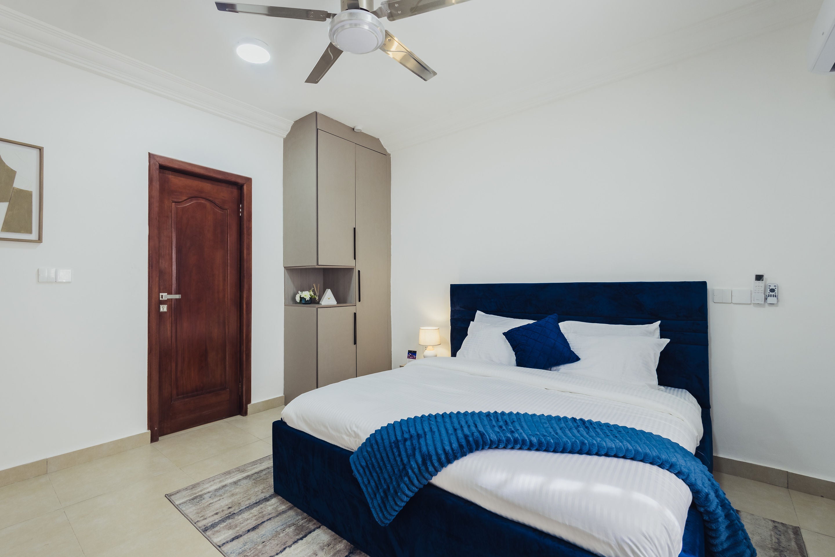 Bedroom with navy throw and framed art